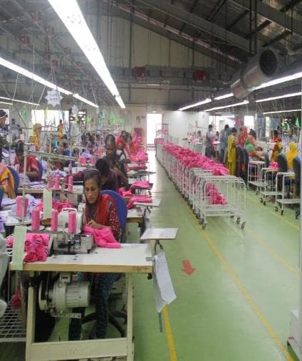 Garment workers sewing inside an apparel production workshop
